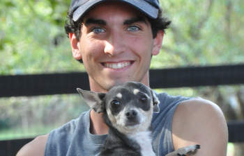 Countryside Pet Estate young male worker with a petite dog in his arms